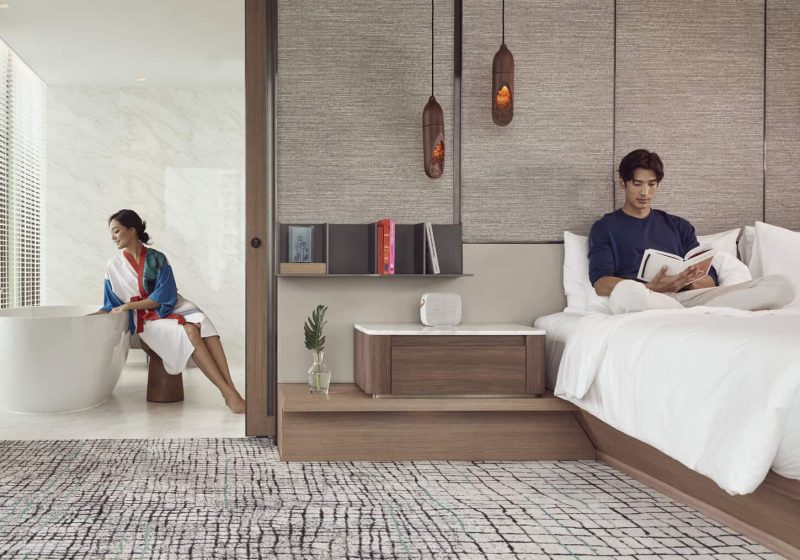 A couple enjoying the view from their room at Kimpton Maa-Lai Bangkok
